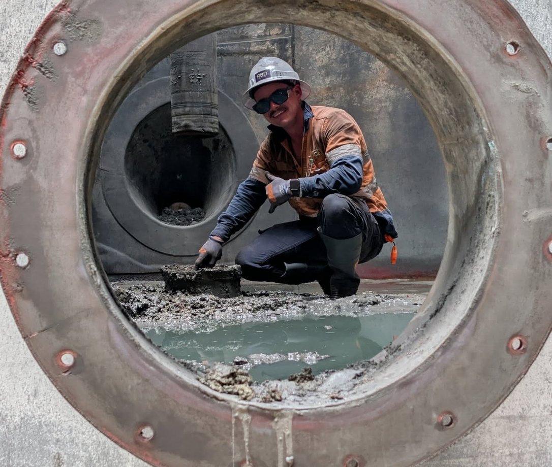 R8D maintenance team member undertaking work inside industrial equipment