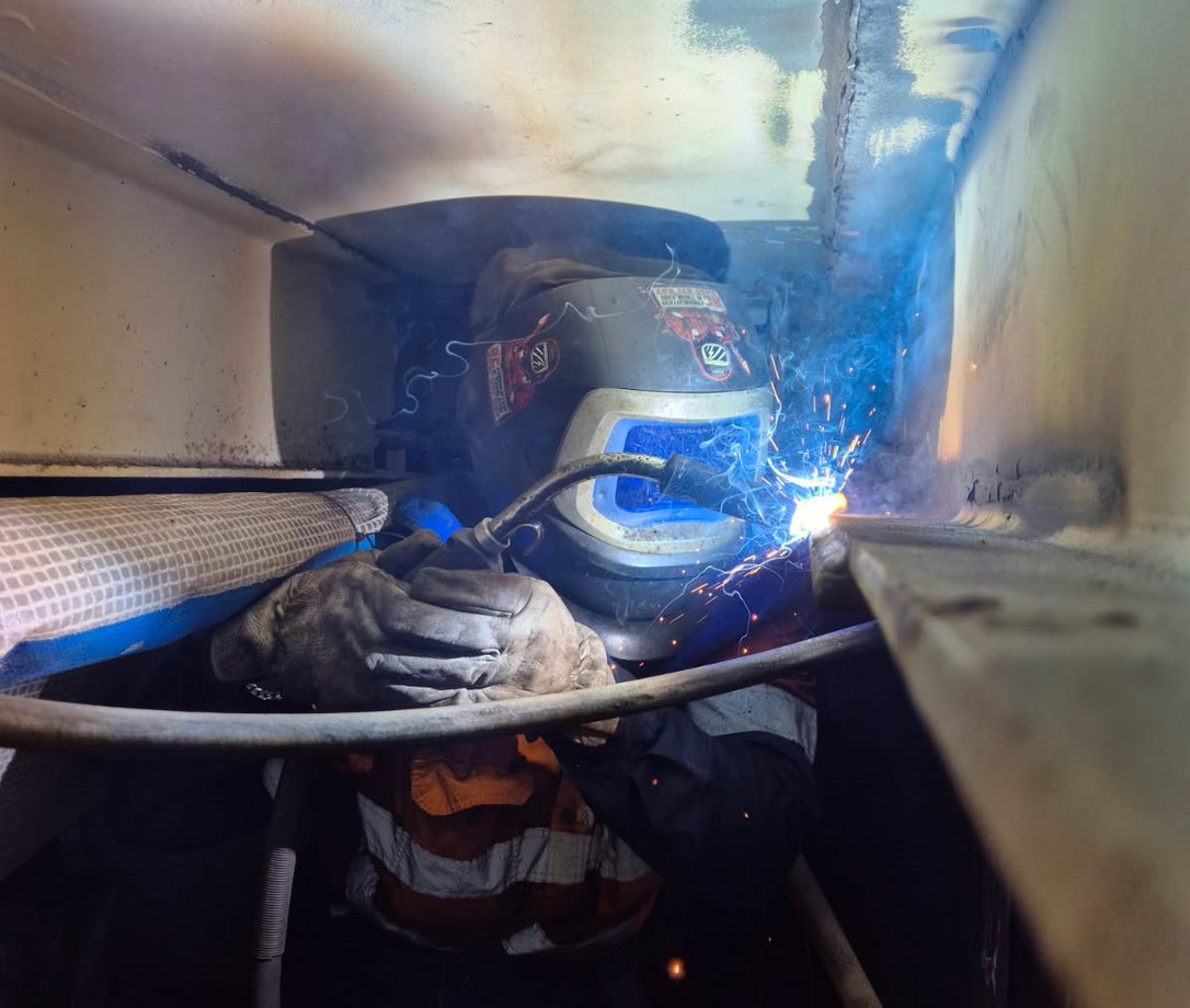 R8D tradesperson welding on industrial equipment