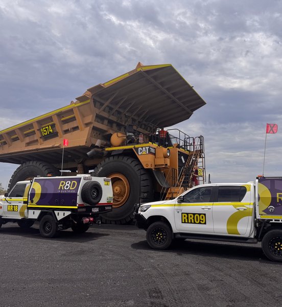 CAT 789B haul truck with raised tray beside R8D service vehicles